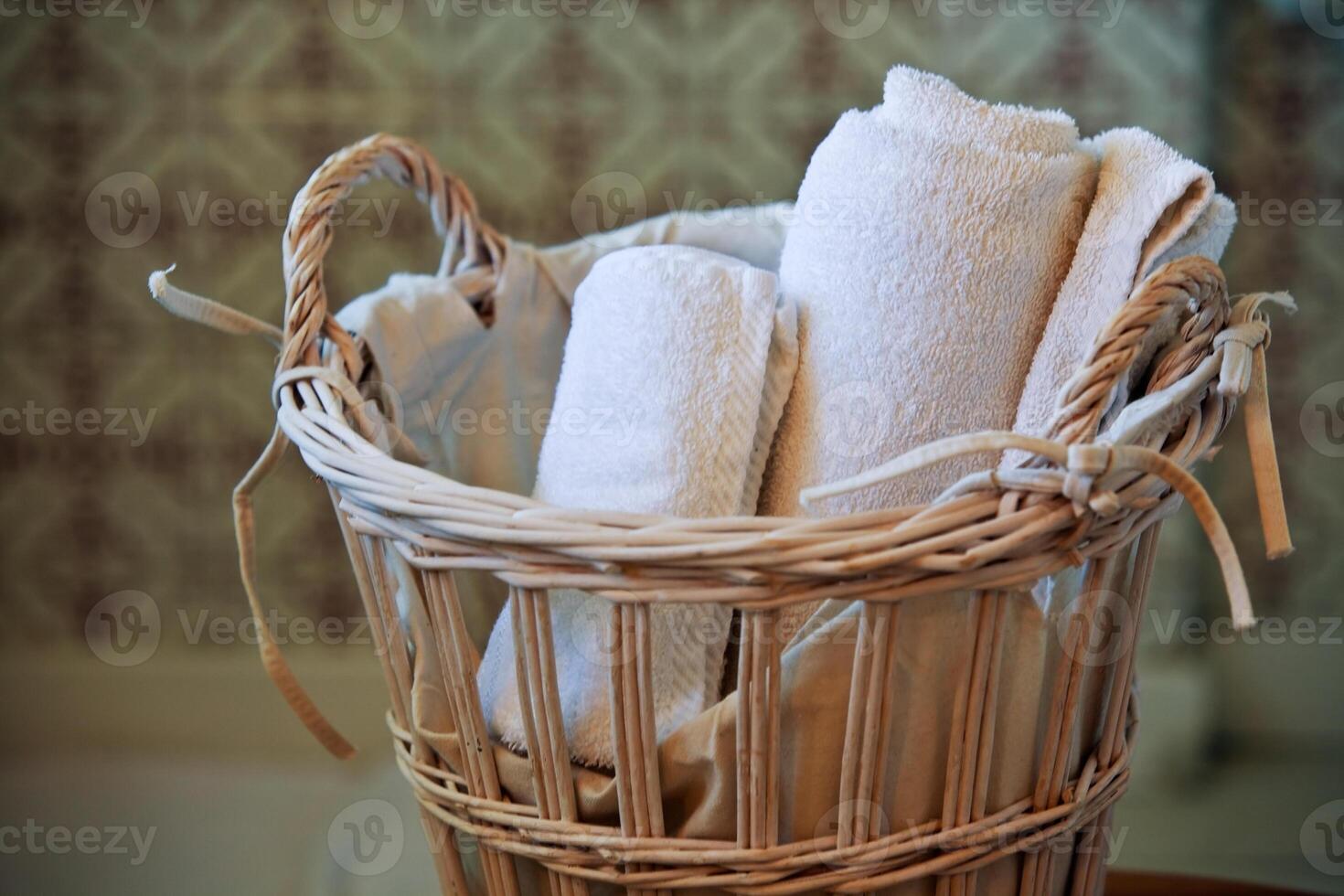 two white rolled towels in wicker basket photo