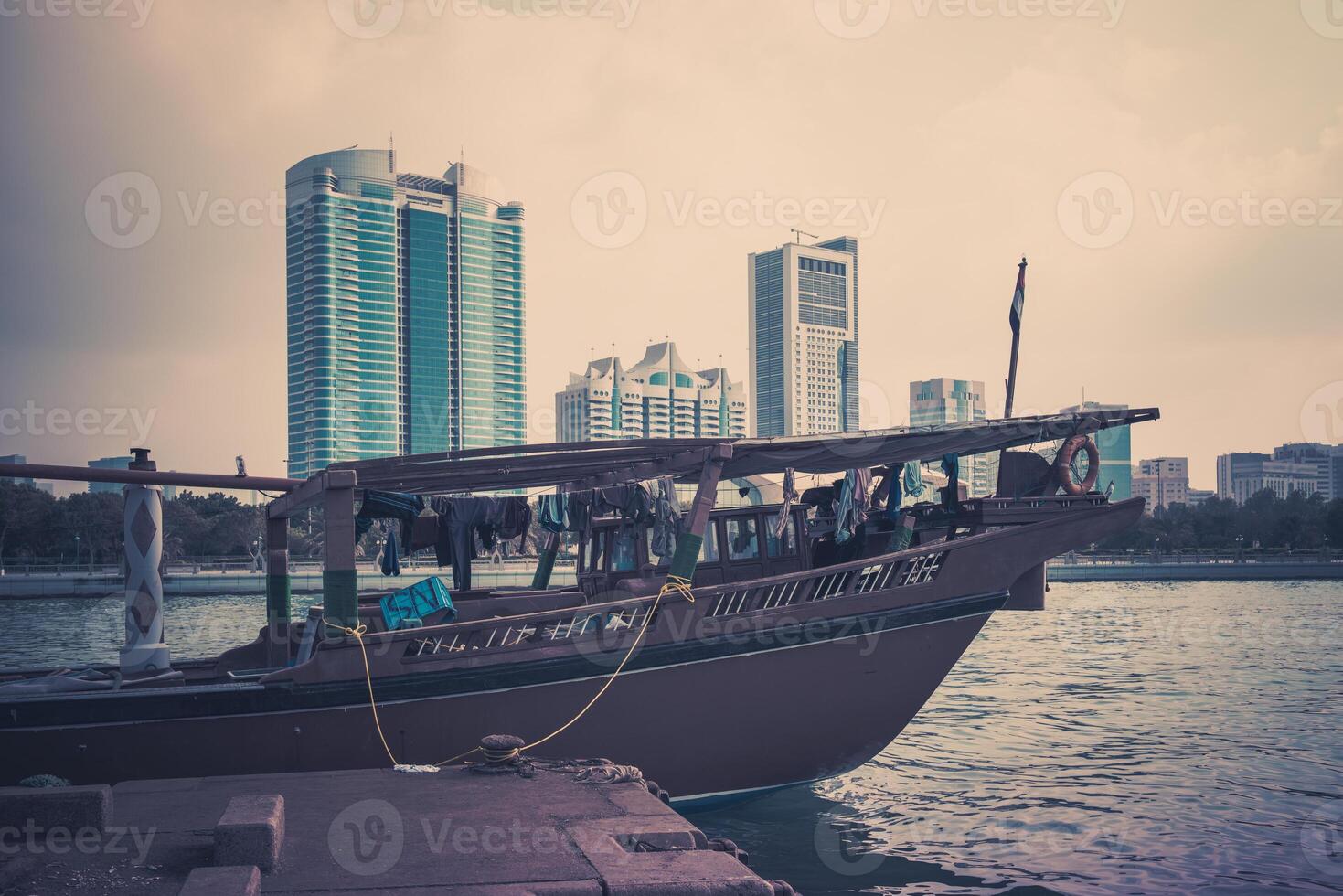 Abu Dhabi buildings skyline with old fishing boats photo