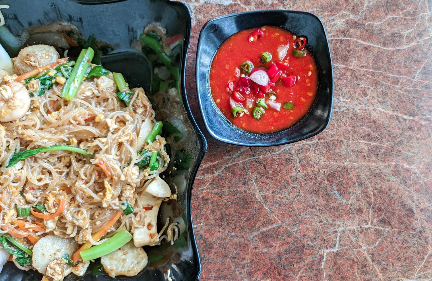 Selective focus of fried seafood vermicelli or bihun goreng with spicy tomato sauce is good for breakfast. photo