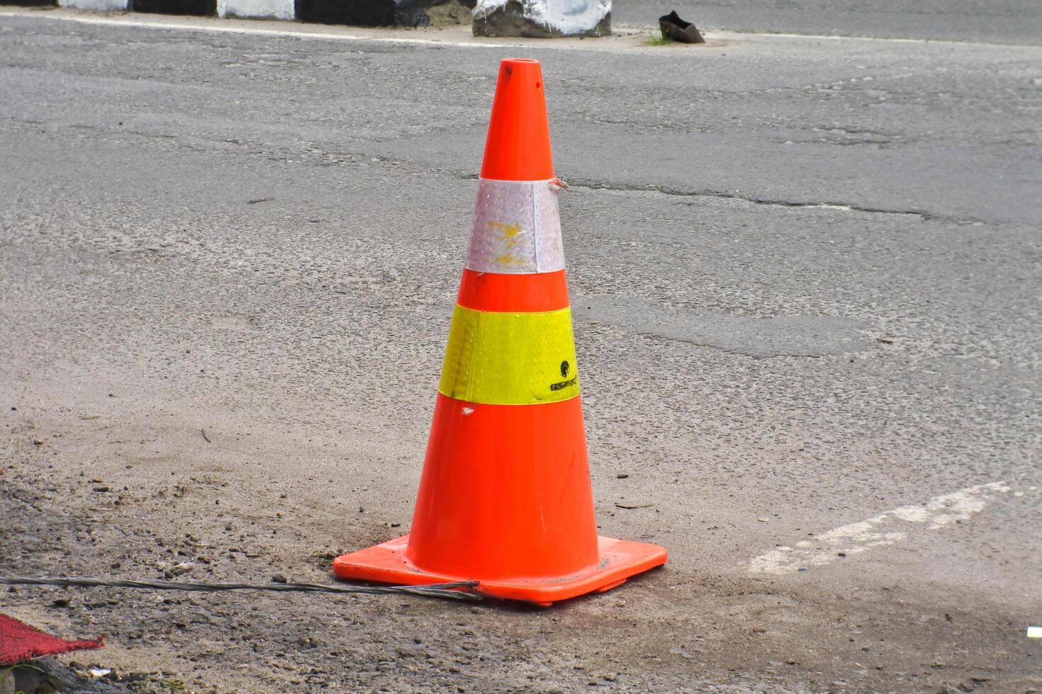 Traffic cone orange white pylon isolated on outdoor background photo