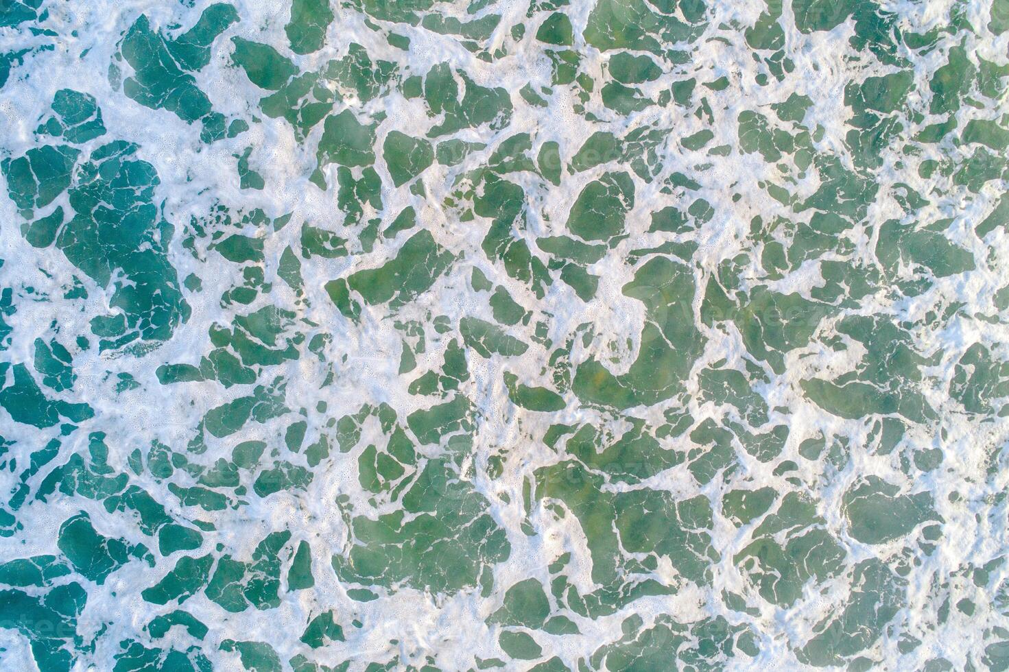 close-up zenith view of seawater on the shore of a beach, textured background marine concept photo