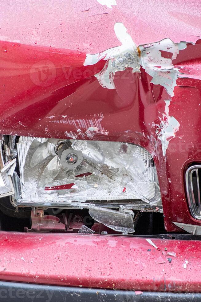 front view of the side of a red car dented by traffic impact photo