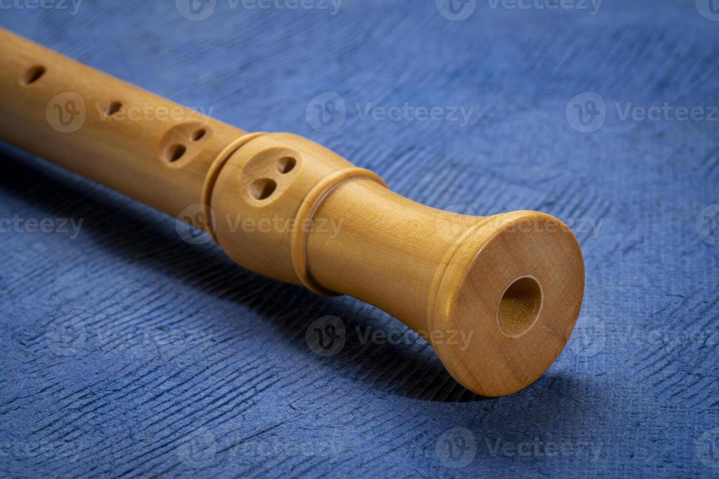 foot of wooden recorder flute instrument, classic German style, against art paper photo