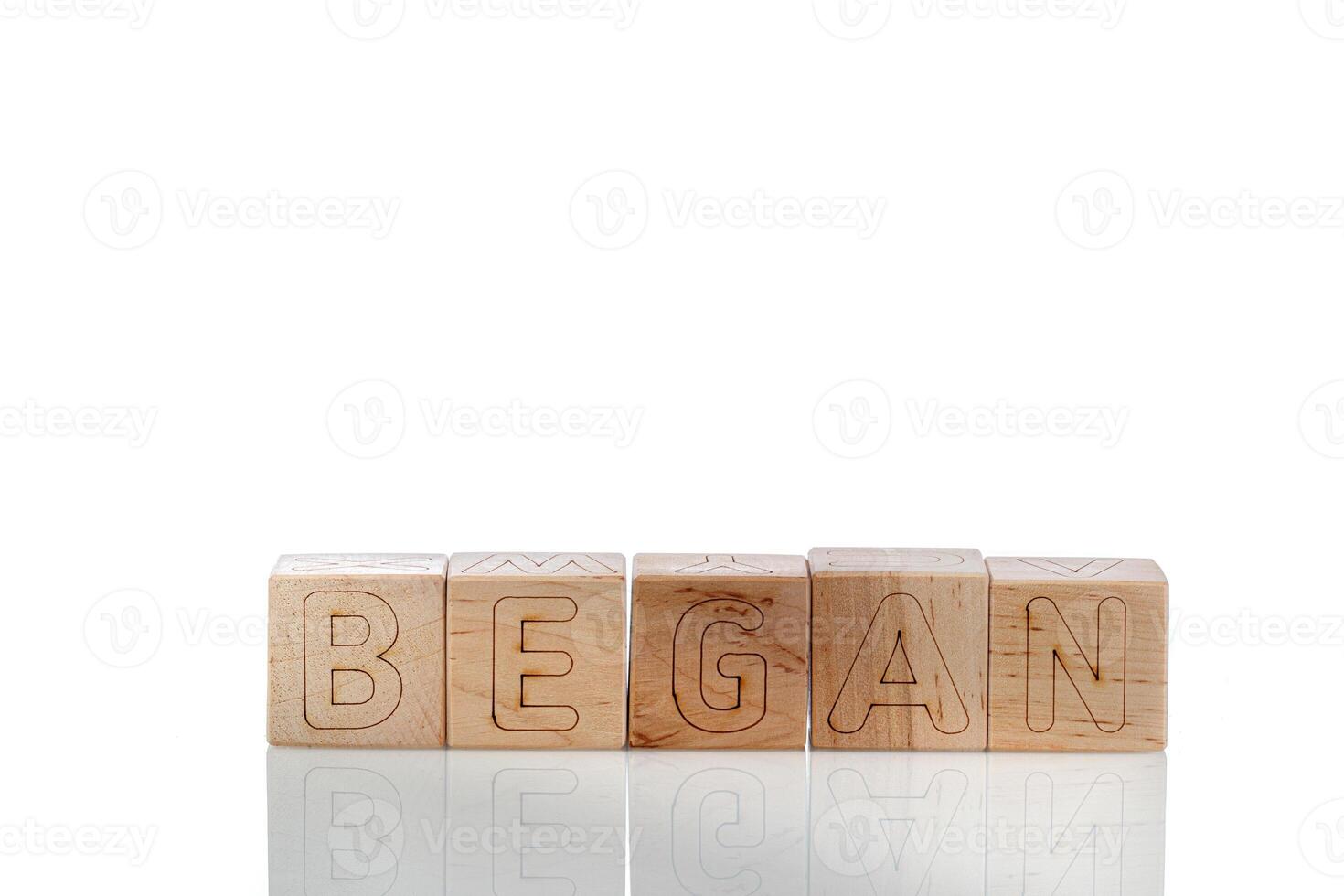 Wooden cubes with letters began on a white background photo