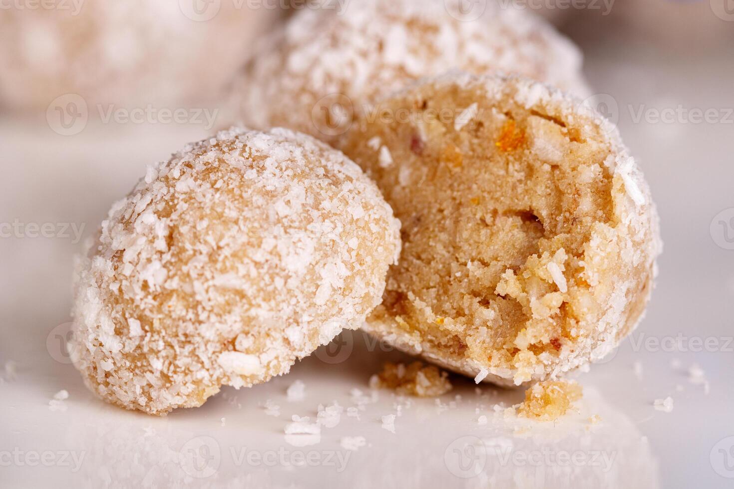 Beautiful sweets with coconut on a white plate on a black background photo