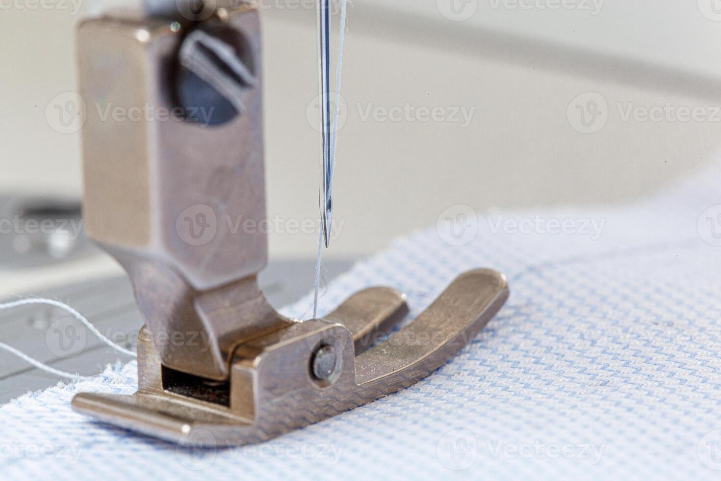 Sewing machine needle with thread and fabric photo