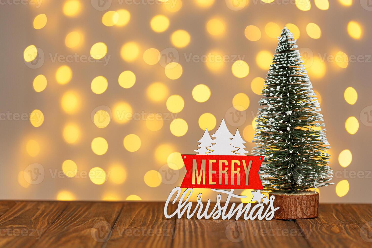 Christmas tree and the inscription Merry Christmas against the background of blurry lights photo