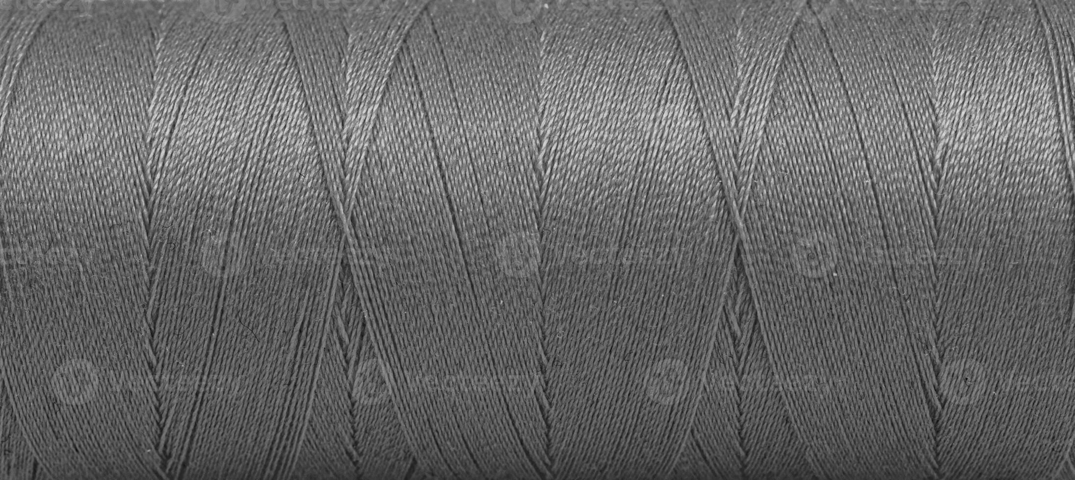 Texture of threads in a spool of grey color on a white background photo