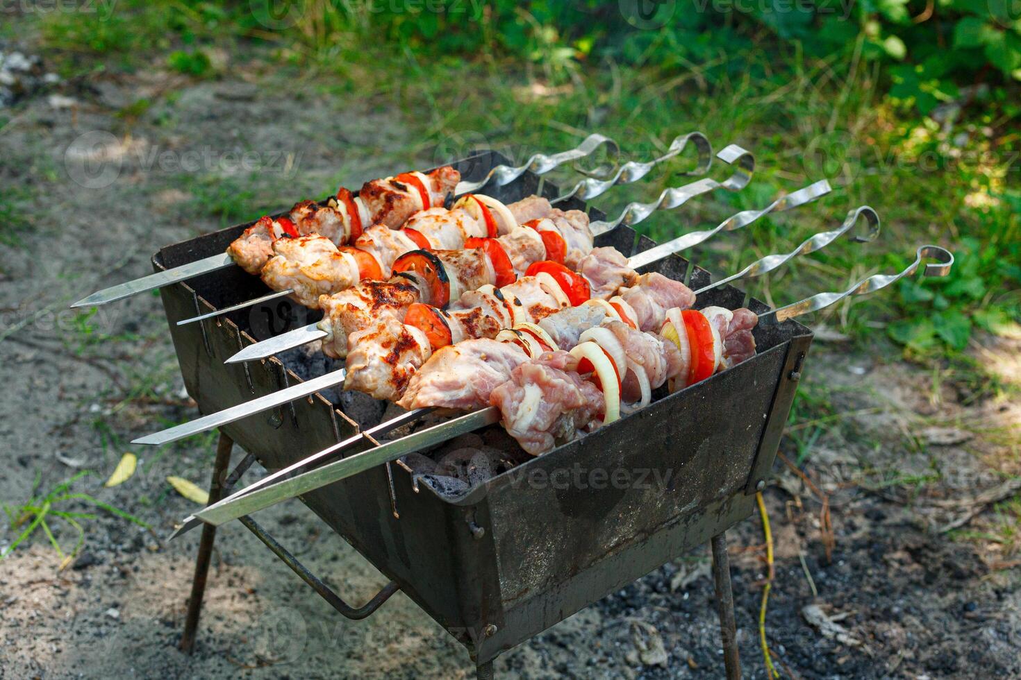 Cooking barbecue with vegetables on skewers. Roasted meat on the grill photo