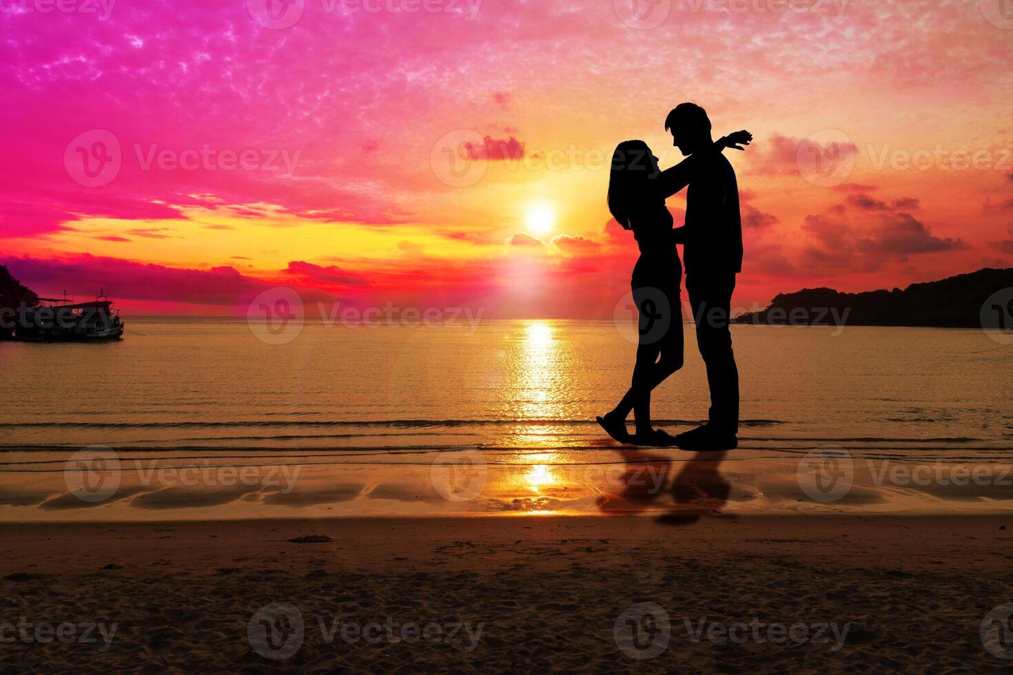 Silhouette happy young couple embracing each other with sunset at tropical beach with copy space. People standing on the beach with beautiful sky. Concept love and valentines day. photo