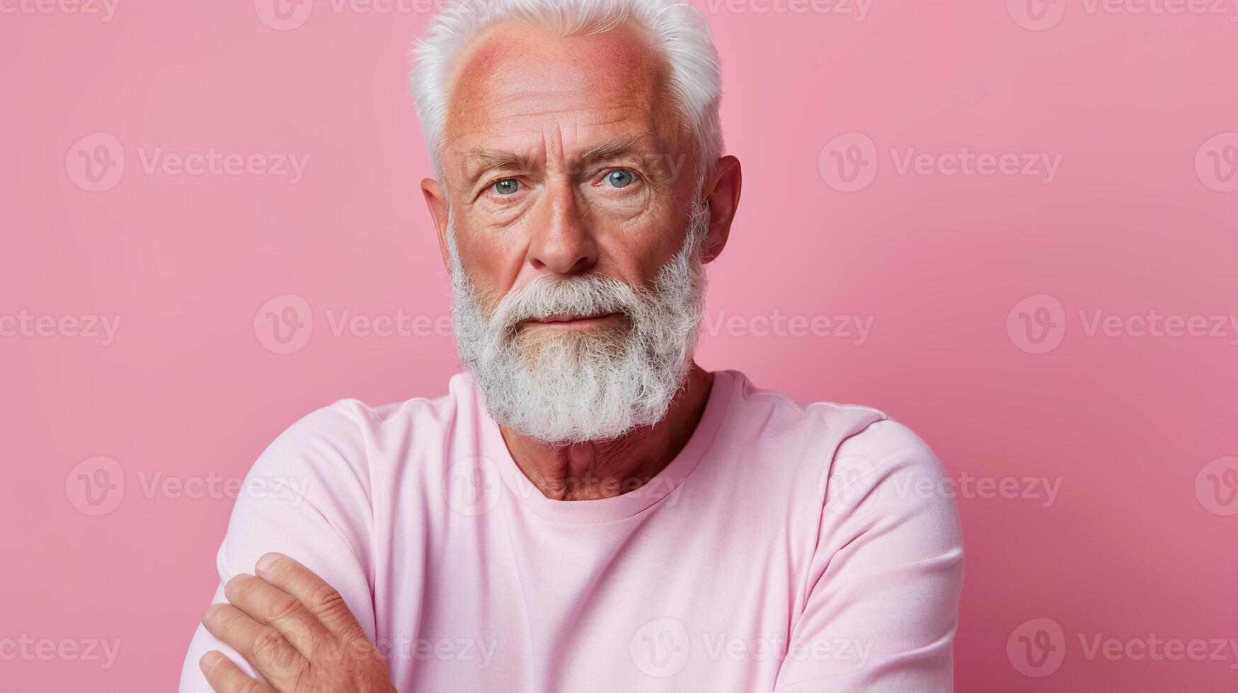 Caucasian elderly male with beard in pink shirt against pink background. photo