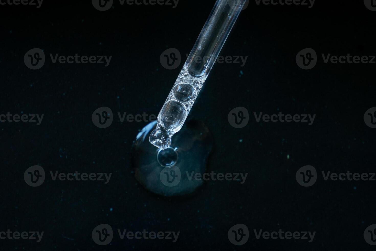 Pipette drop on black background photo