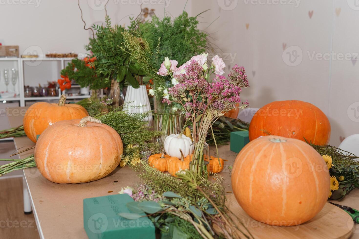 Flower arrangement in a pumpkin, autumn interior decor. Creating handmade autumn decor. photo