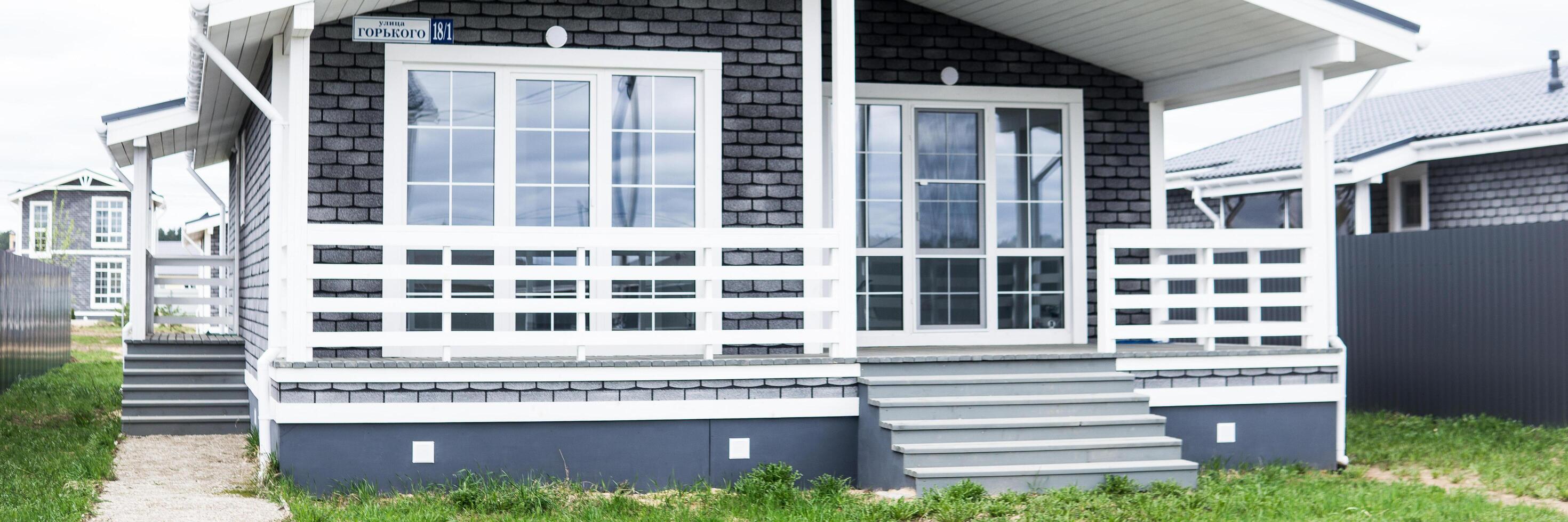 TVER, RUSSIA - MART 11, 2023. The house is made of timber lined with gray brick. A house with a veranda. The concept of living outside the city. photo