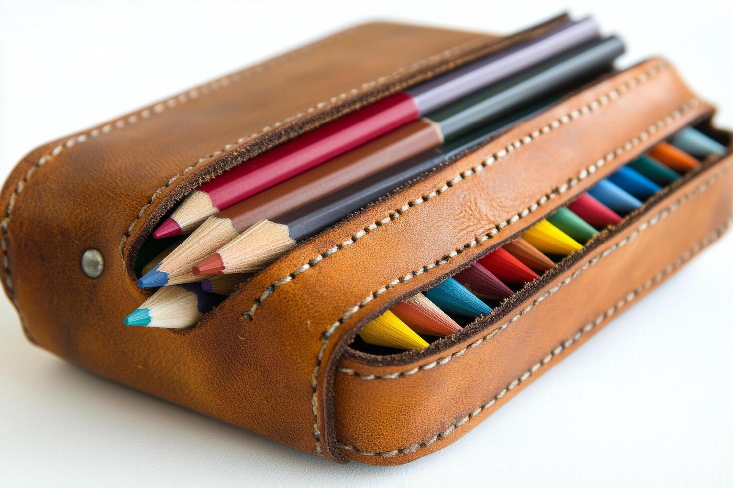 Colorful pencils arranged neatly in a brown leather case on a wooden surface photo