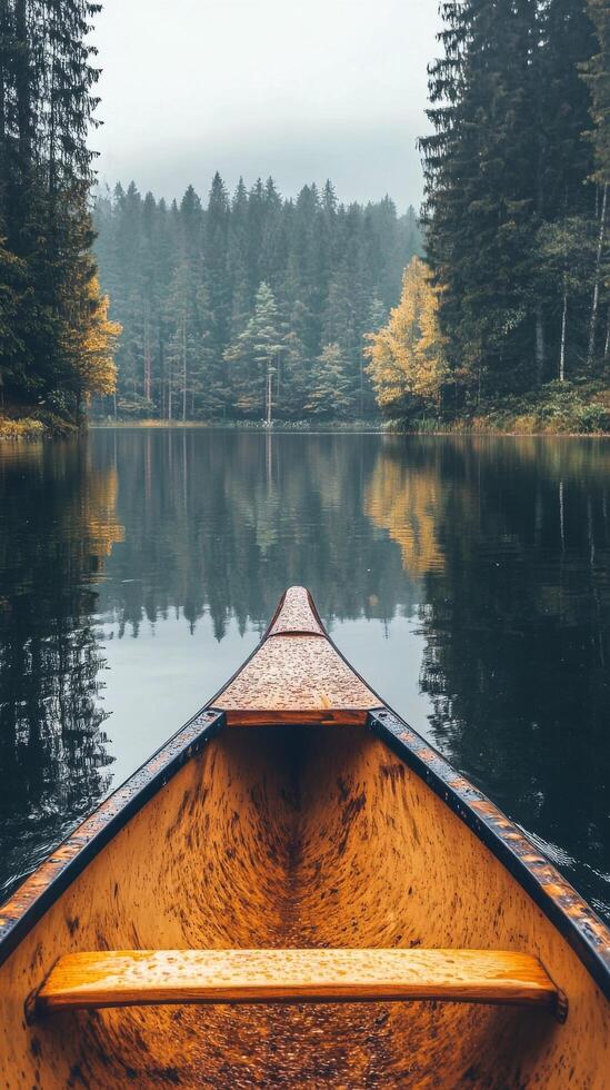 Canoeing on a peaceful lake surrounded by autumn trees under a cloudy sky photo