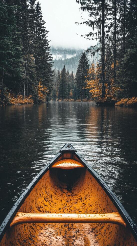 Canoeing on a peaceful lake surrounded by autumn trees under a cloudy sky photo