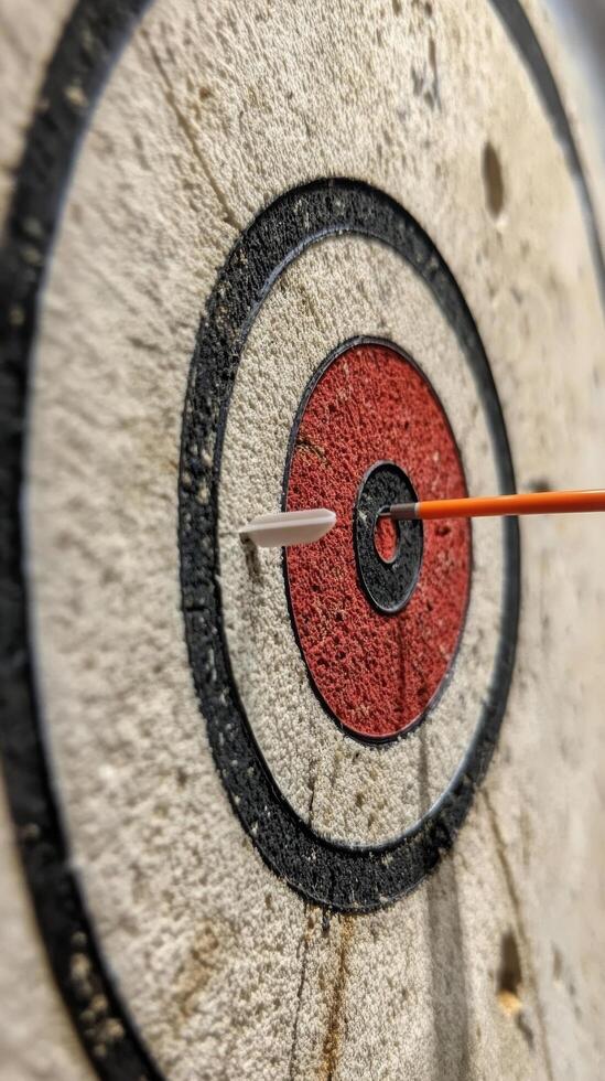 Dart with heart-shaped tip hitting the center of target in a serene blue water background photo