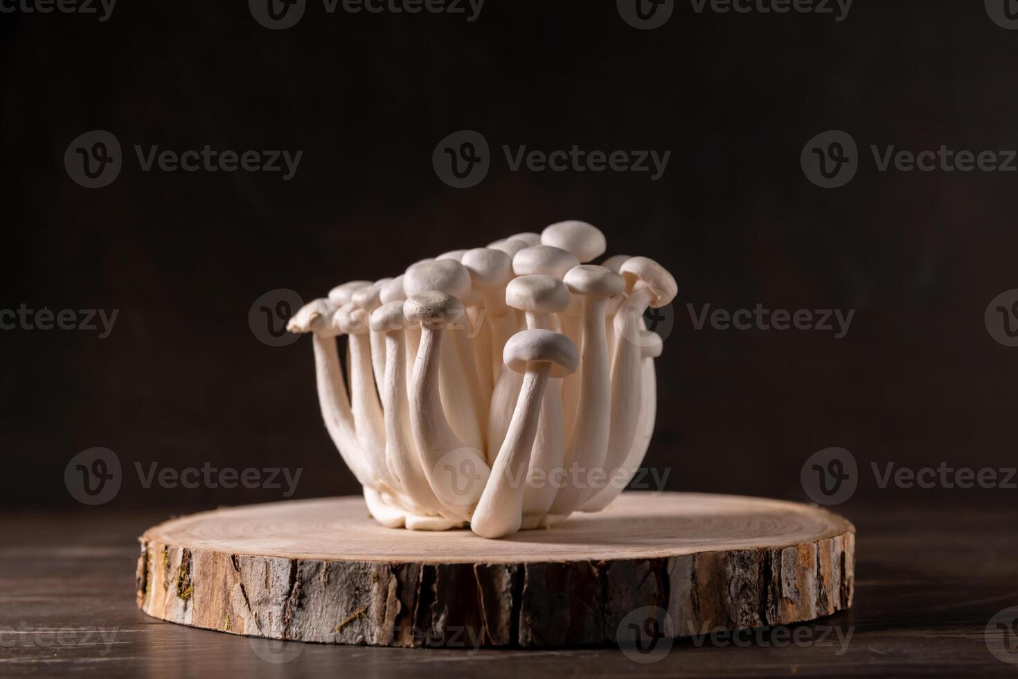 Closeup of a bunch of shimeji mushrooms on wooden background, with selective focus photo