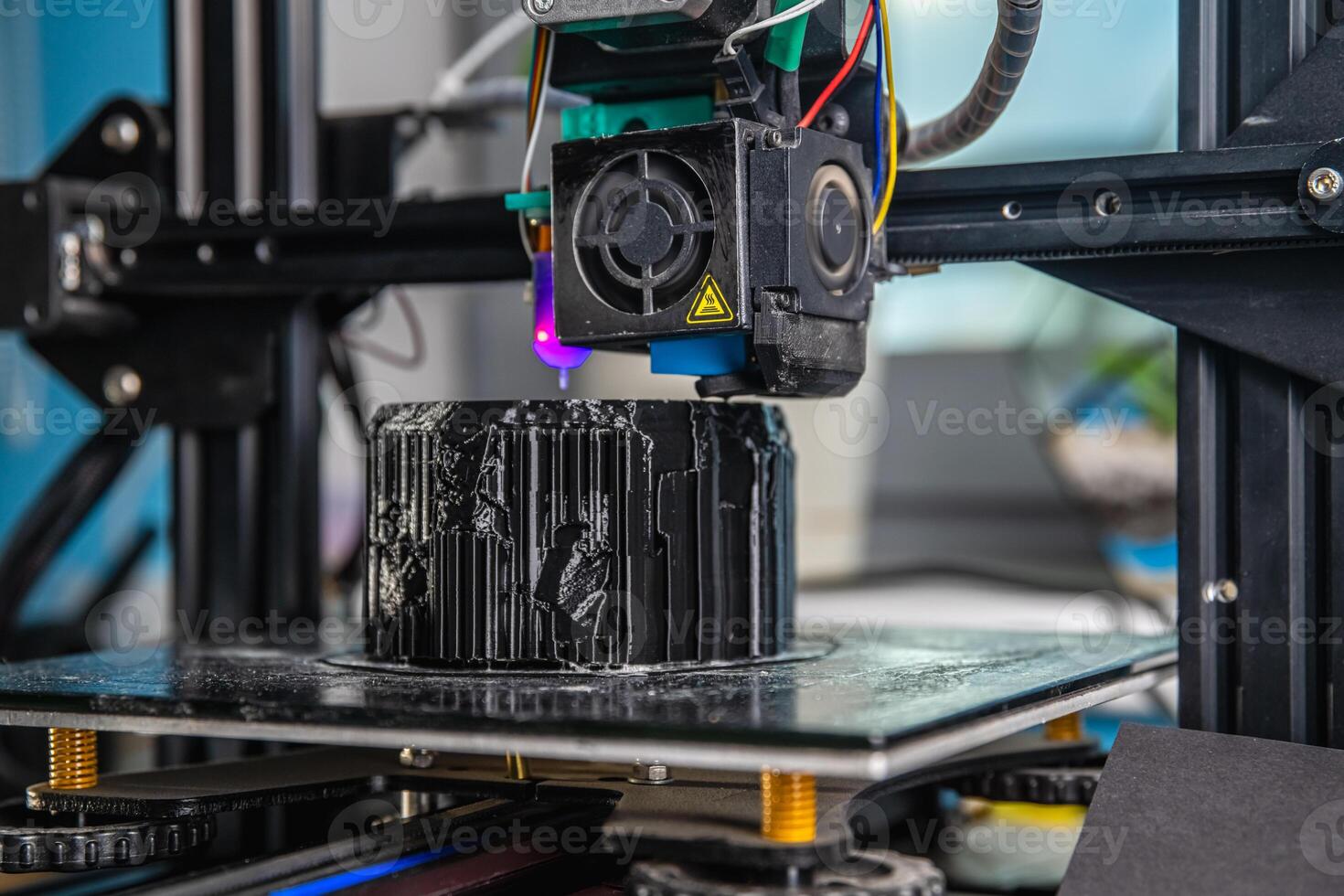 A 3D printer prints a black model. Technology at home photo