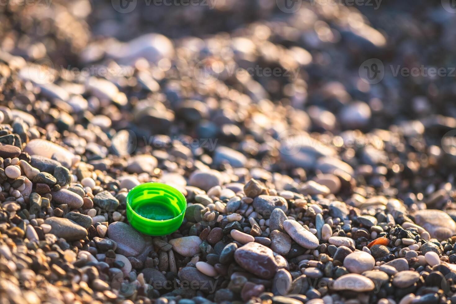 plastic bottle cap on the beach, environmental pollution photo