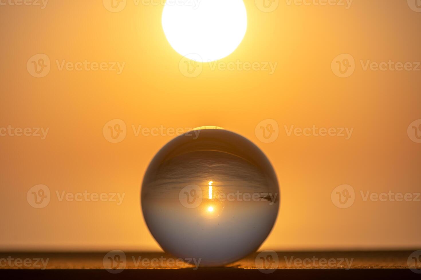 Round glass ball, in the ball sunset on the sea, concept summer, vacation, travel, vacation by the sea photo