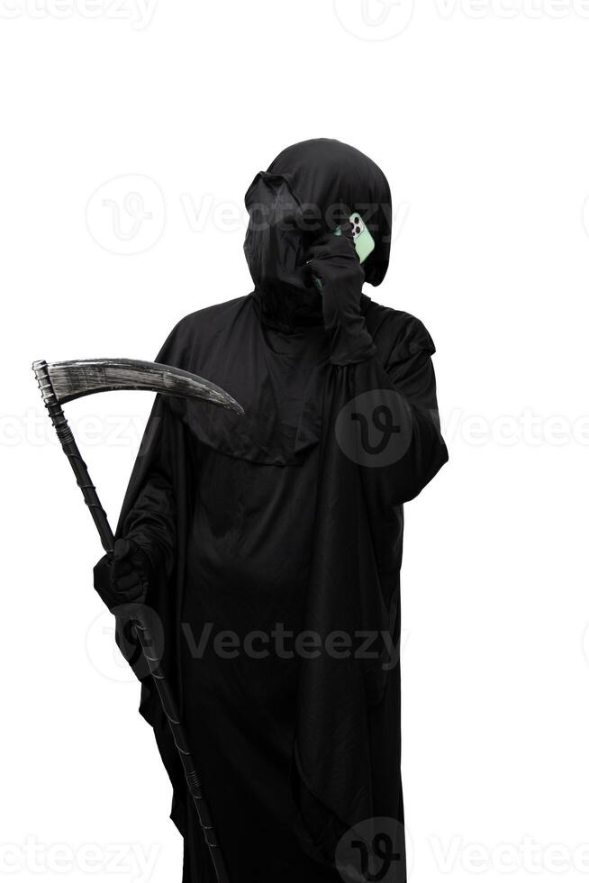 vertical Grim reaper in Halloween costume holding a scythe making a call with a mobile phone photo