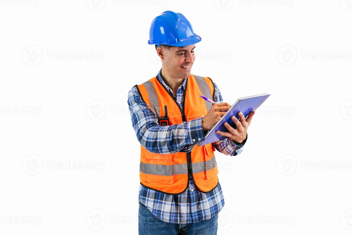 Engineer in reflective orange vest and helmet documenting project details on notebook photo