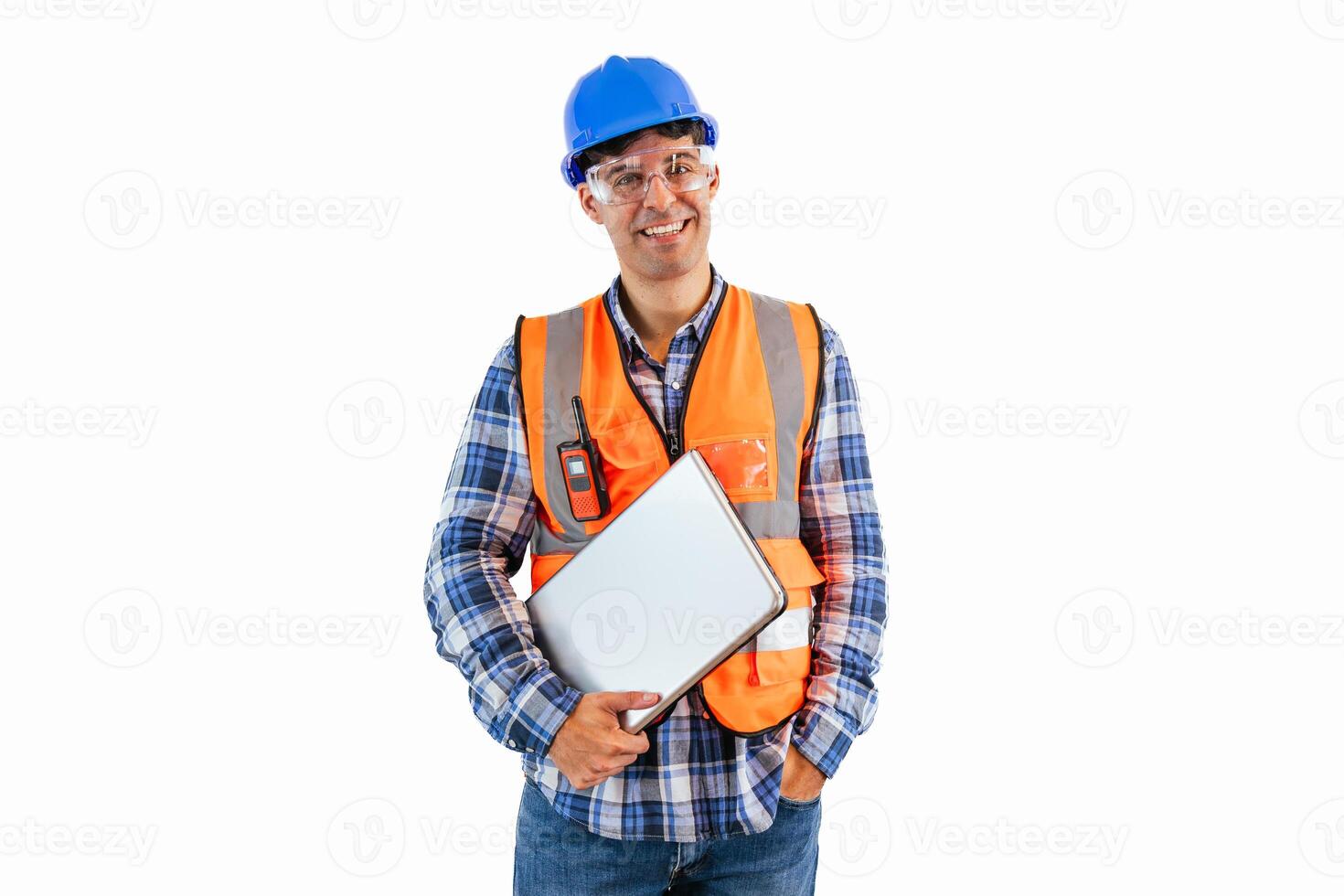 Construction worker smiling while holding laptop wearing safety glasses, helmet, and reflective vest photo