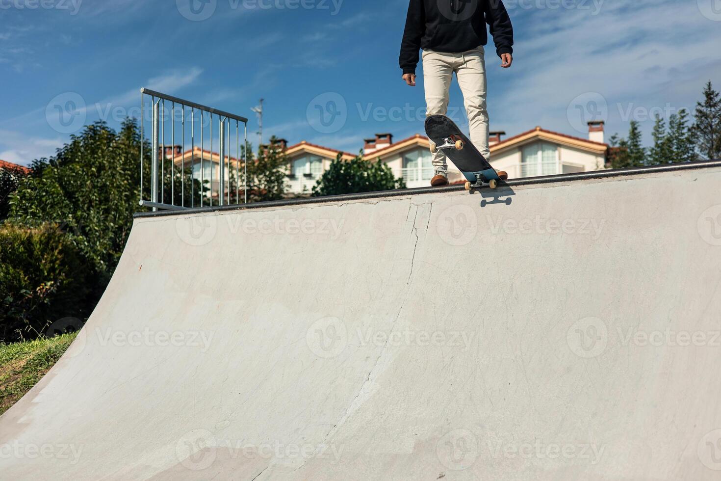 Unrecognizable skater standing on skateboard at edge of half-pipe photo