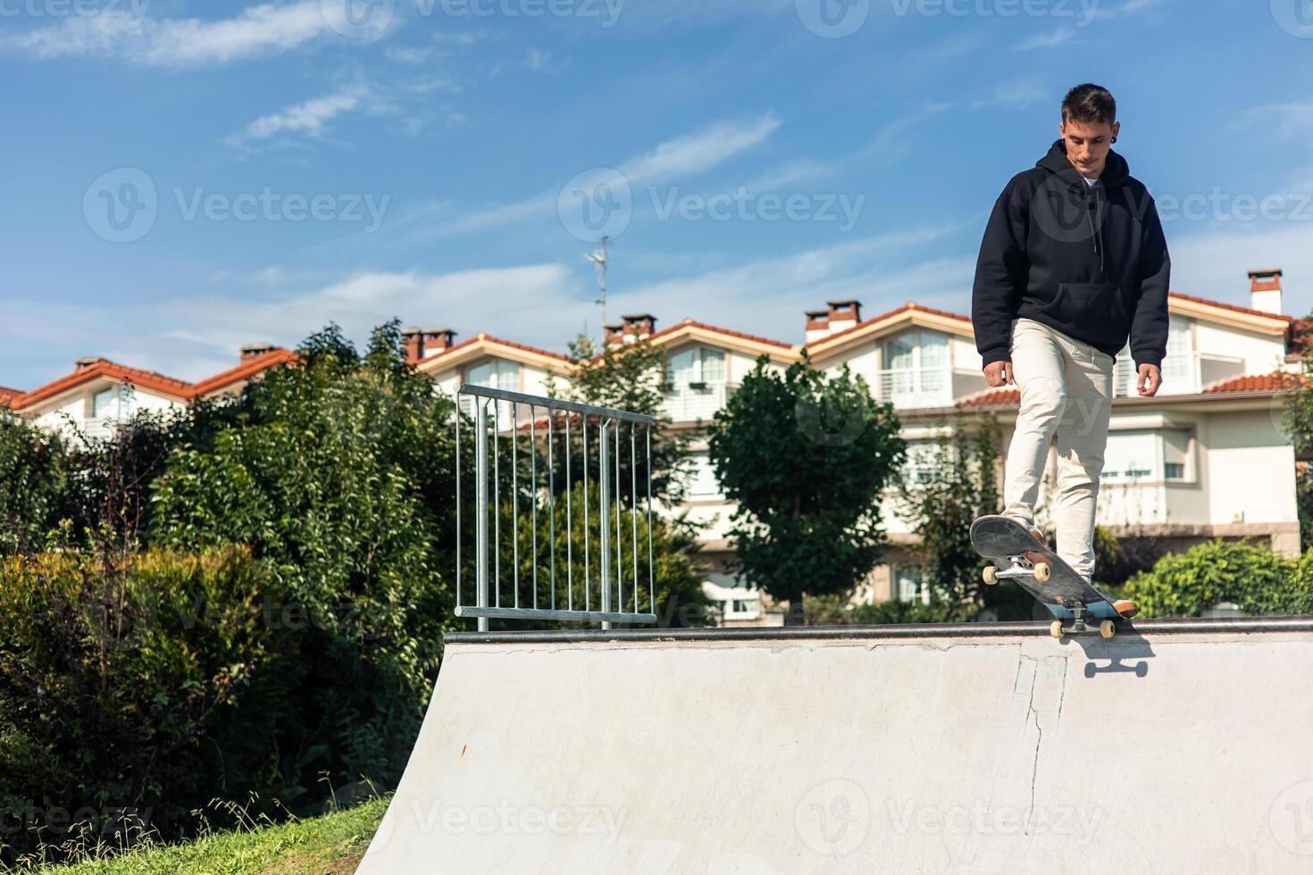 copyspace Concentrated skater on skateboard at edge of half-pipe ready to drop photo