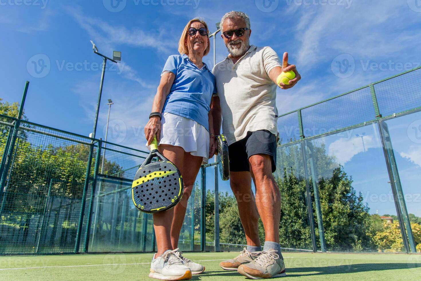 Low-angle shot of elderly padel players celebrating victory on court photo