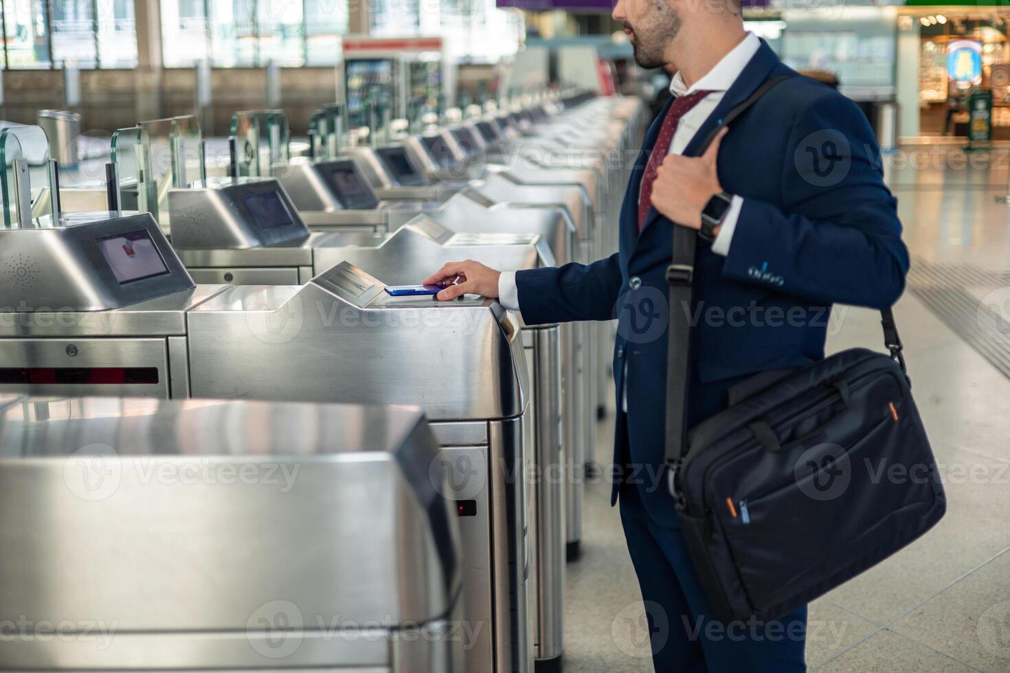 Unrecognizable businessman using contactless smartphone at metro barriers for work commute photo