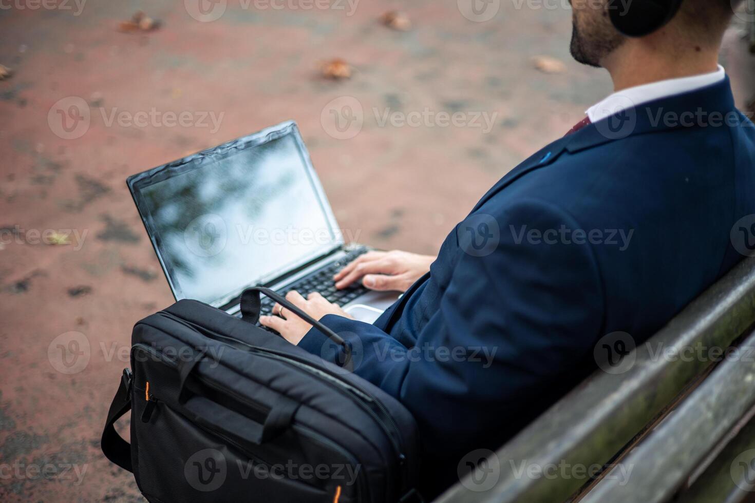 Unrecognized businessman working outdoors on company projects with laptop photo