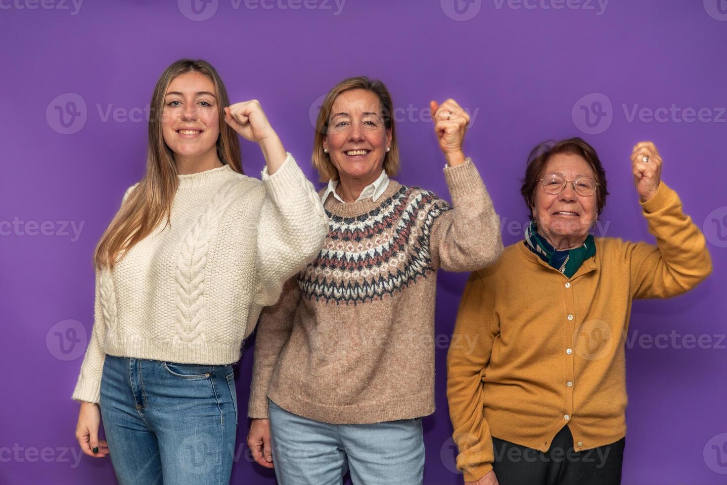 Three generations of women raising fists in a sign of victory photo