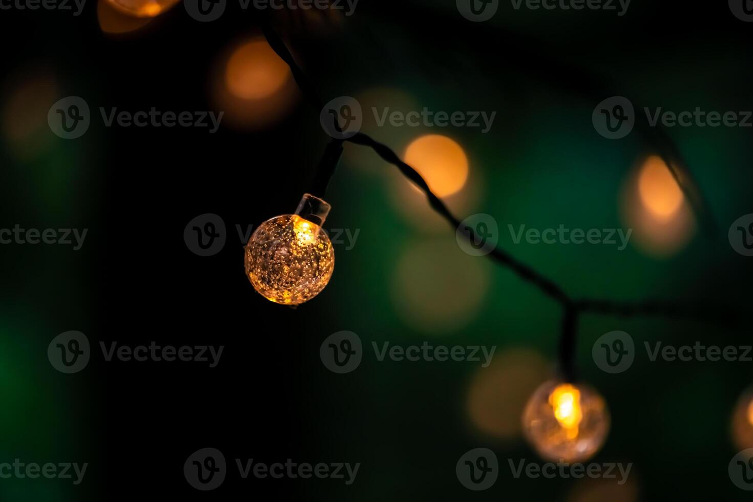 Glowing small warm string lights against a dark green background, creating a cozy, festive atmosphere perfect for celebrations, romantic evenings, or holiday gatherings photo
