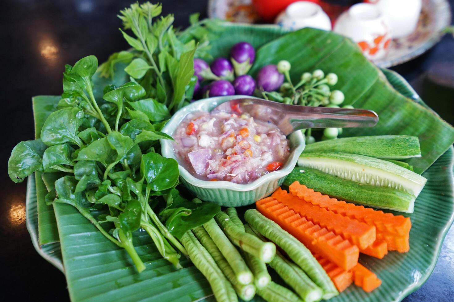 Close up chili paste served with fresh vegetables photo