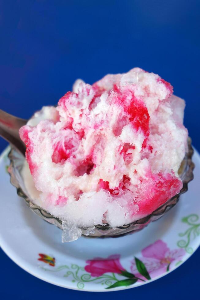 Close up Thai style shaved ice dessert topped with condensed milk, syrup and sweet toppings photo