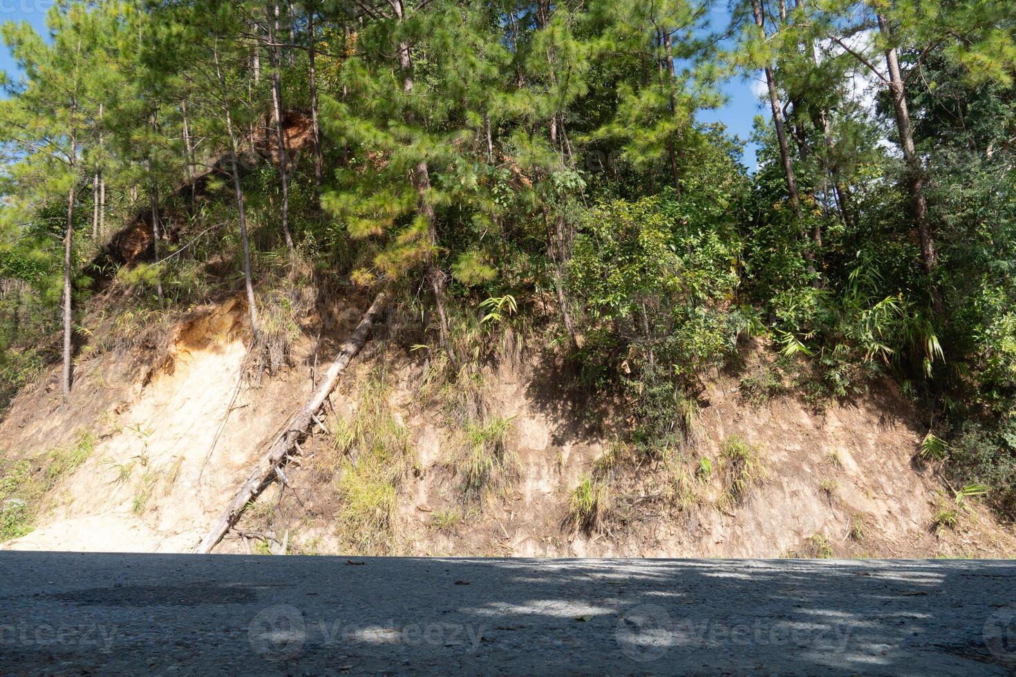 Horizontal view of asphalt road under the shade. background is a mountain ridge covered with trees. At Rak Chang Viewpoint, Pai, Mae Hong Son, Thailand. photo