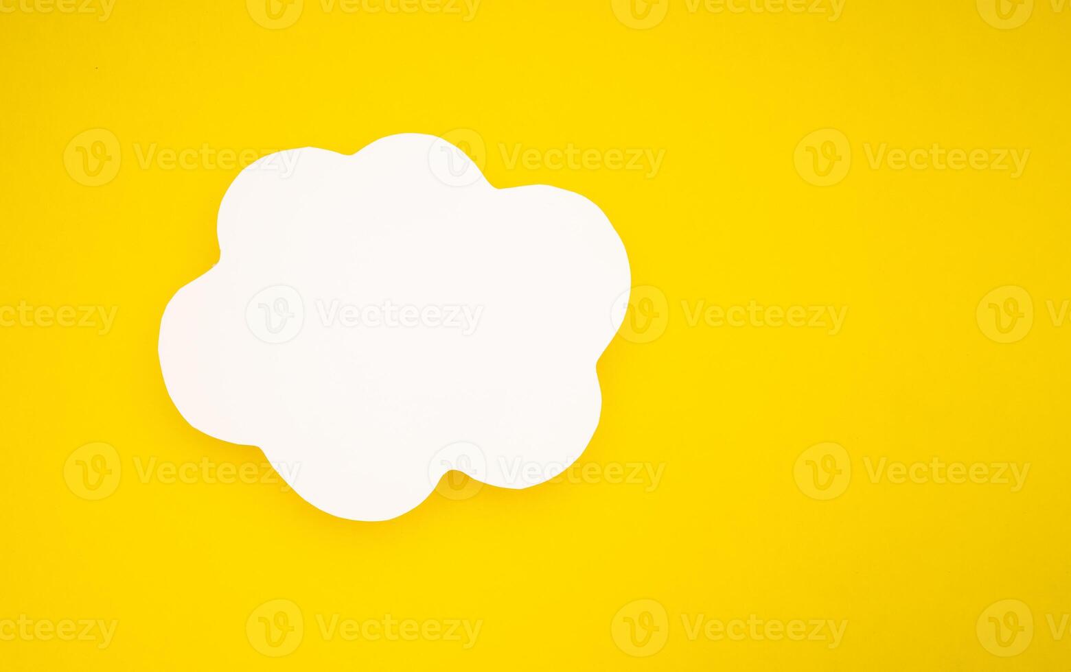 A blank white speech bubble clouds over a light yellow background photo