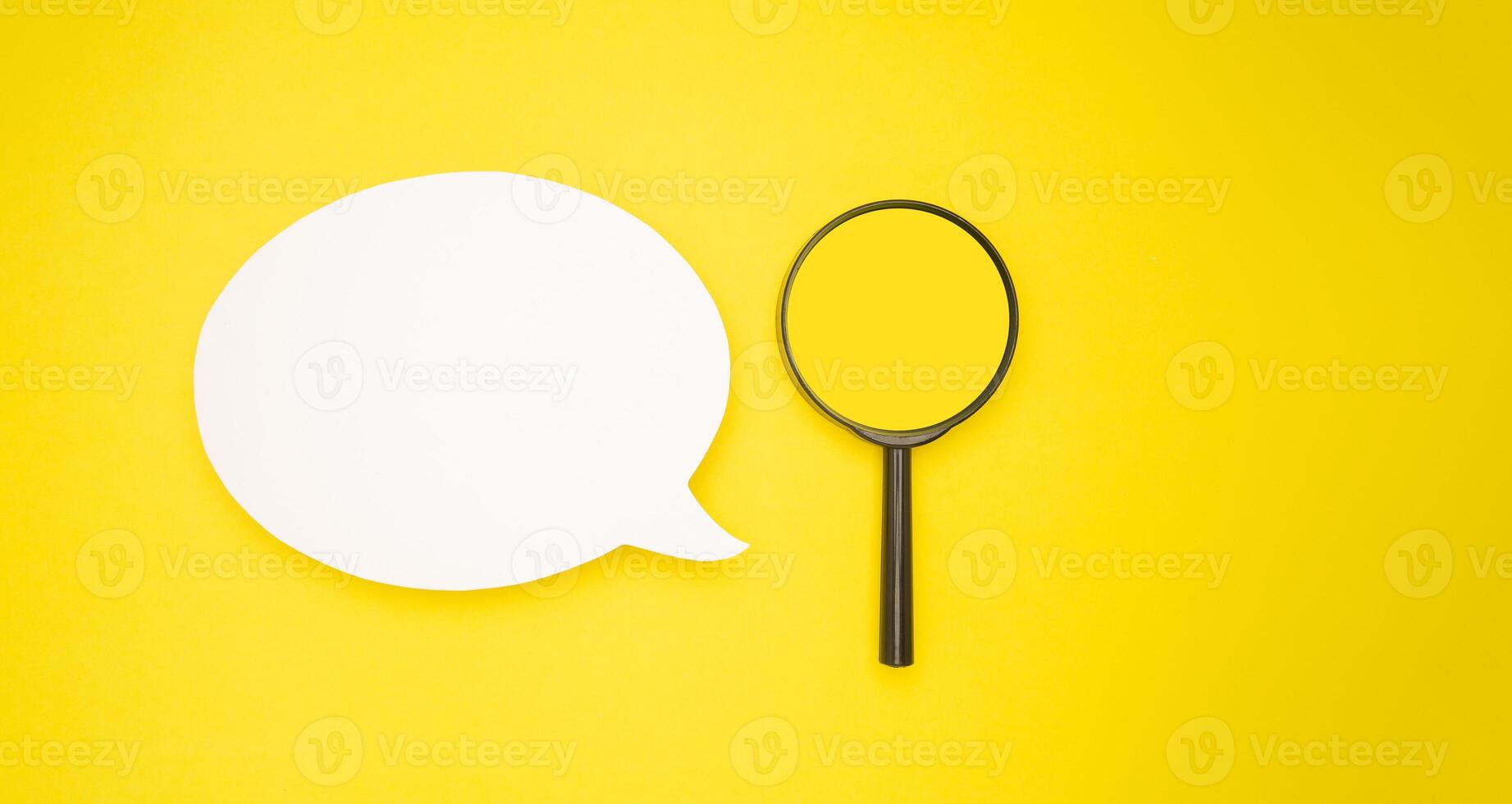 Top view of a blank white speech bubble and a magnifying glass isolated on a light green background photo