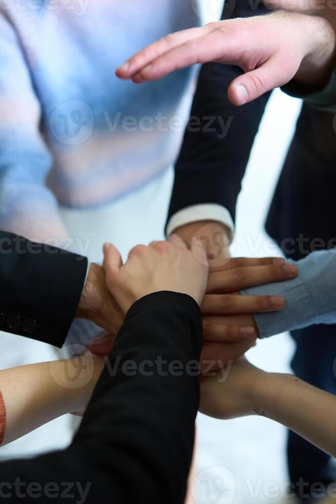 A top view of business people joining hands in a circle, symbolizing unity, collaboration, and shared success in the workplace photo