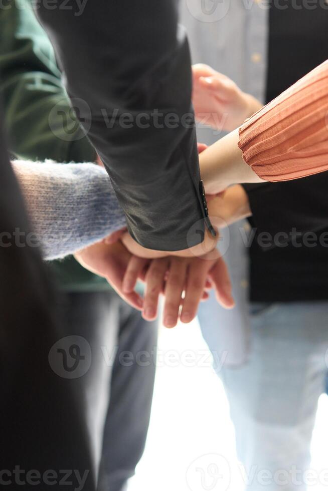 A top view of business people joining hands in a circle, symbolizing unity, collaboration, and shared success in the workplace photo