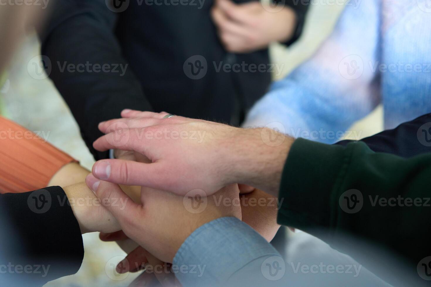 A top view of business people joining hands in a circle, symbolizing unity, collaboration, and shared success in the workplace photo