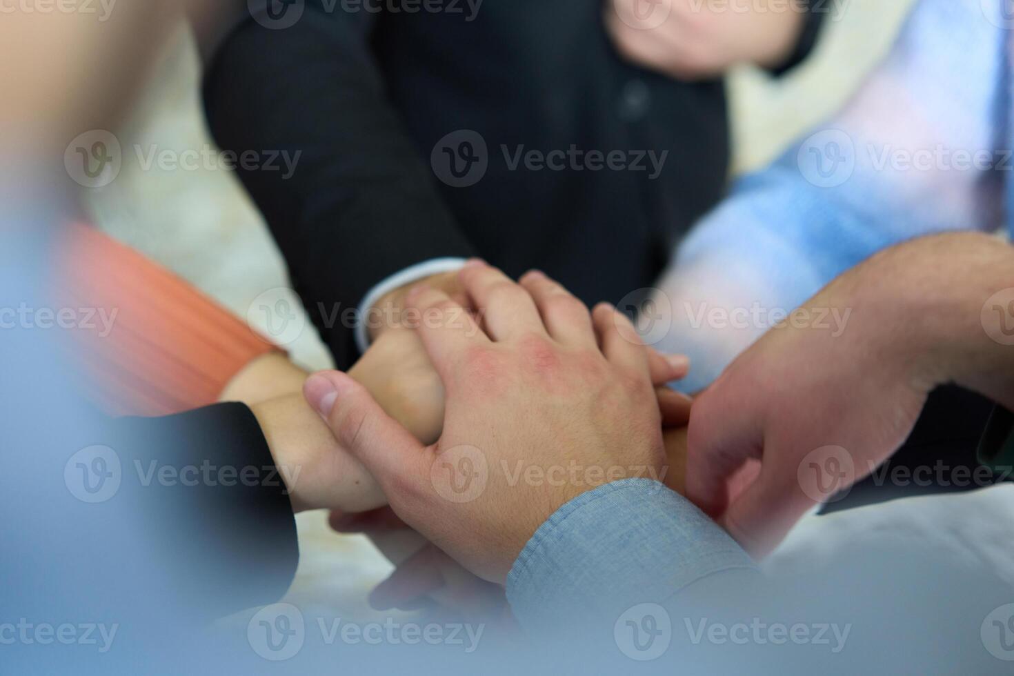 A top view of business people joining hands in a circle, symbolizing unity, collaboration, and shared success in the workplace photo