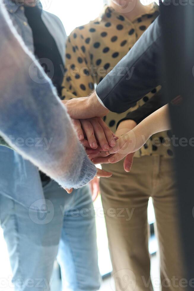 A top view of business people joining hands in a circle, symbolizing unity, collaboration, and shared success in the workplace photo