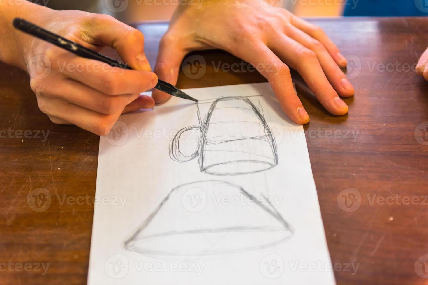 woman hands drawing a draft of a future clay cup photo