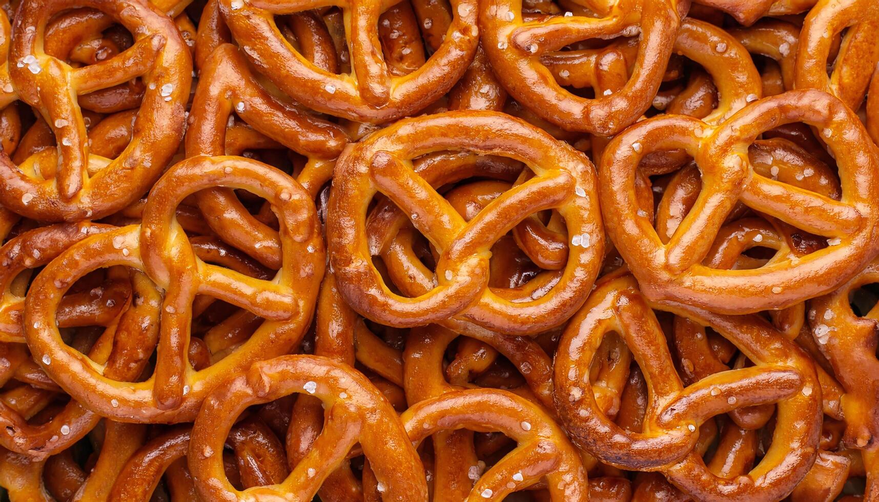 golden brown pretzels with visible salt crystals in a chaotic arrangement perfect for snacking and party appetizers photo