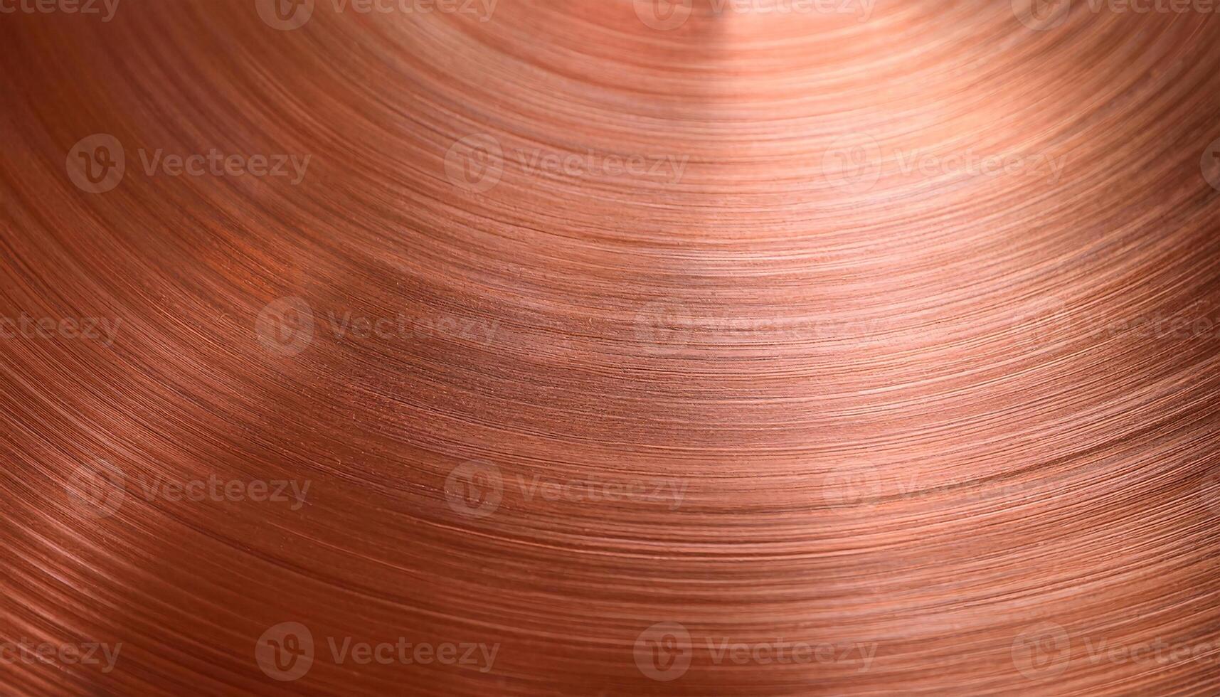 close-up of a polished copper surface with circular brushed texture and reflective highlights photo