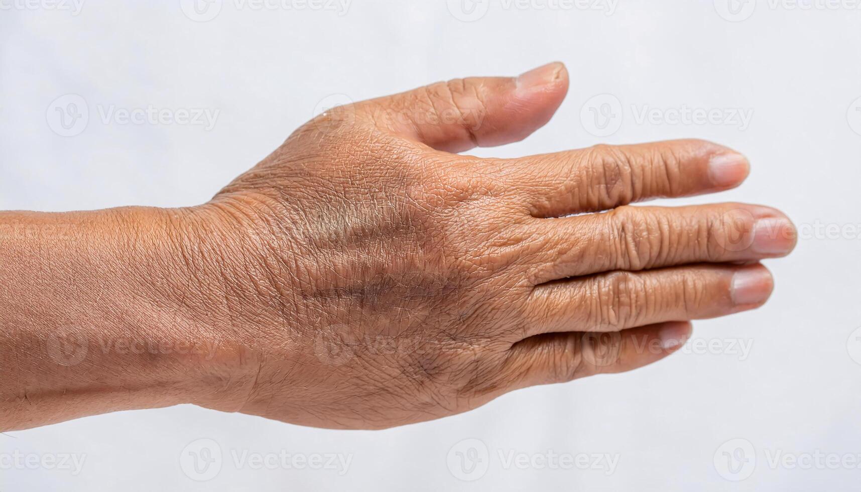 macro image of wrinkles on the back of the hand with visible veins and age spots in isolated white background photo